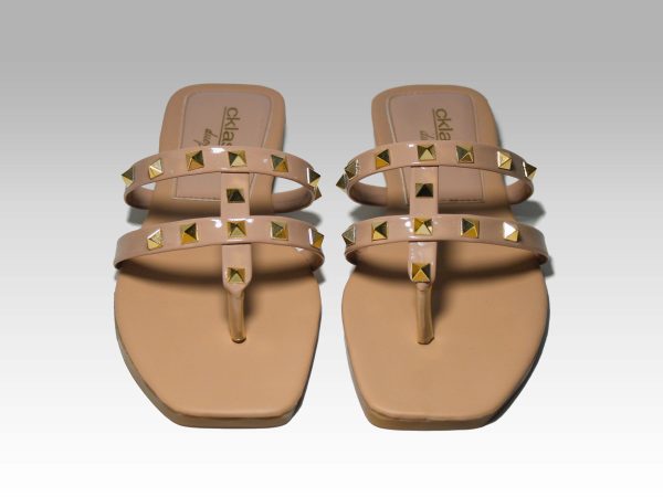 Sandalias de metededo de tiritas beige con pirámides doradas, vista frontal.