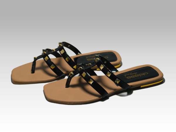 Sandalias de metededo de tiritas negras con pirámides doradas, vista lateral.