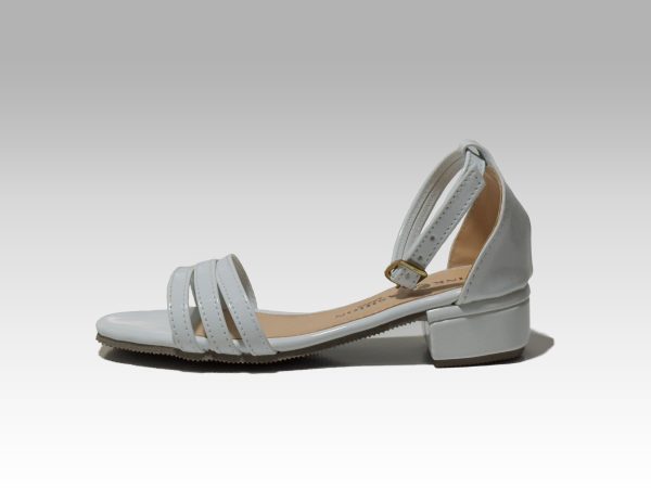 Sandalia blanca de niña con tacón, con tiritas en el empeine y talón con herraje.