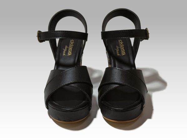 Sandalia negra, de mujer con tacón cuadrado alto, con banda en empeine en forma de cruz, y talón con herraje, vista frontal.